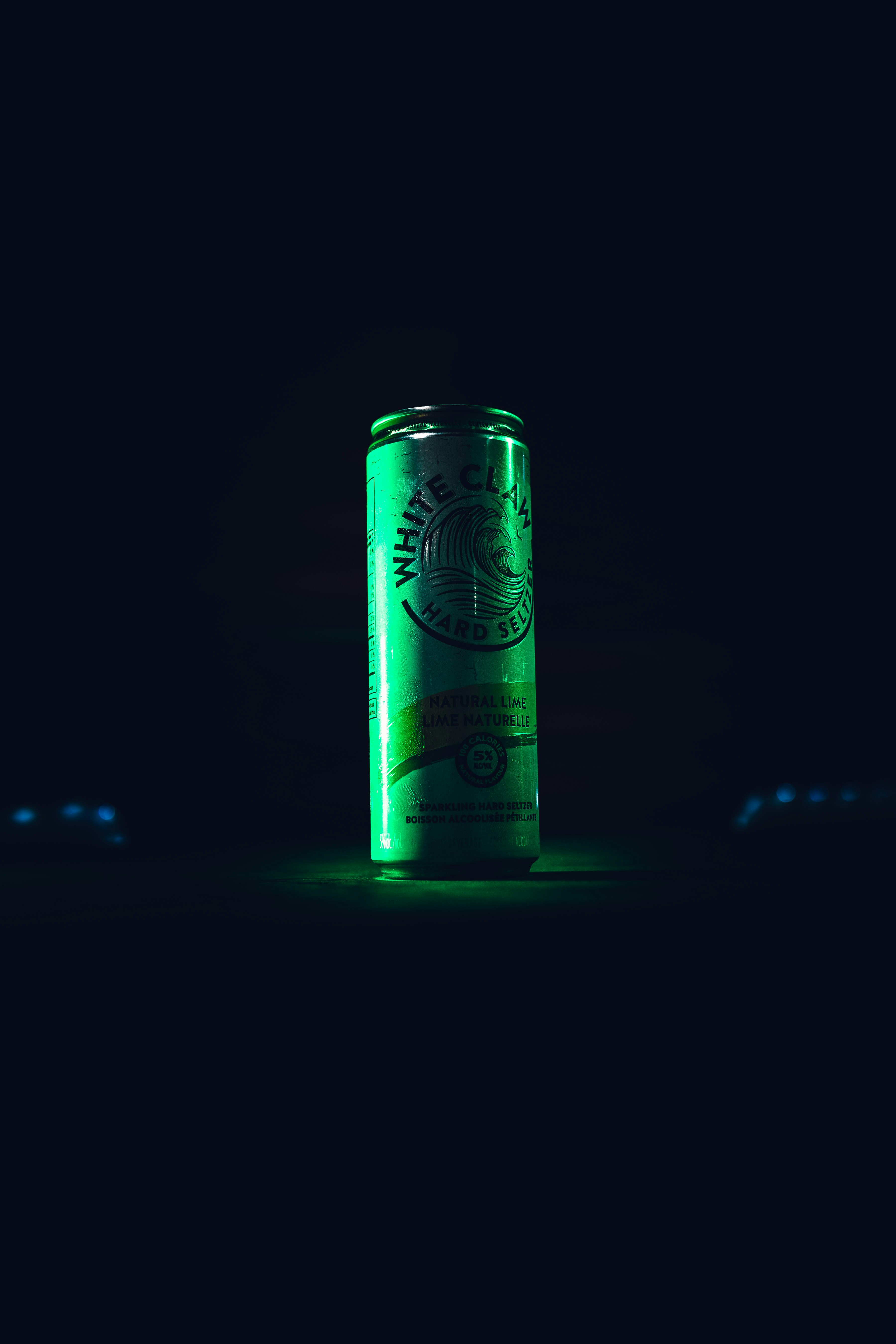 green and white can on black surface